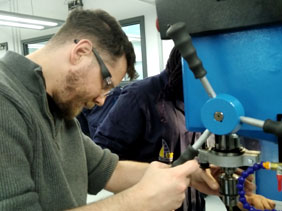 Technician using a drill press